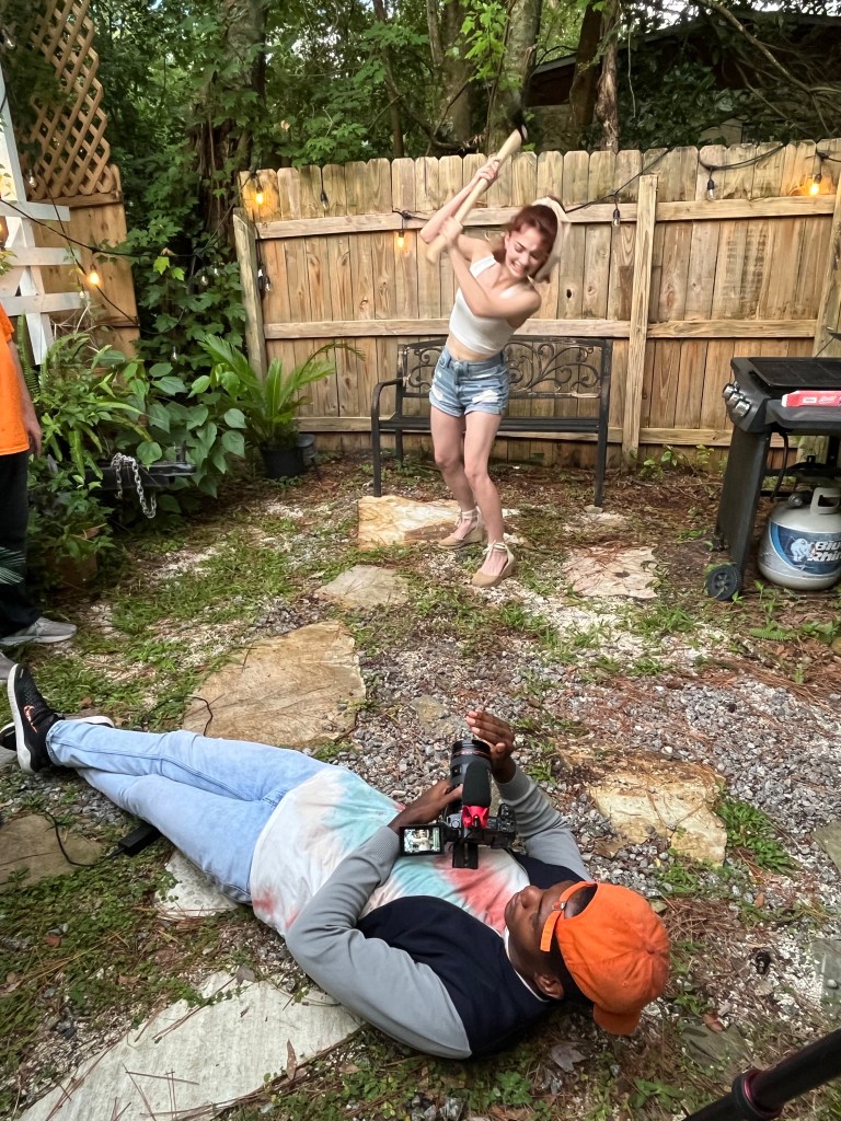 Girl pretends to swing an axe while being filmed.