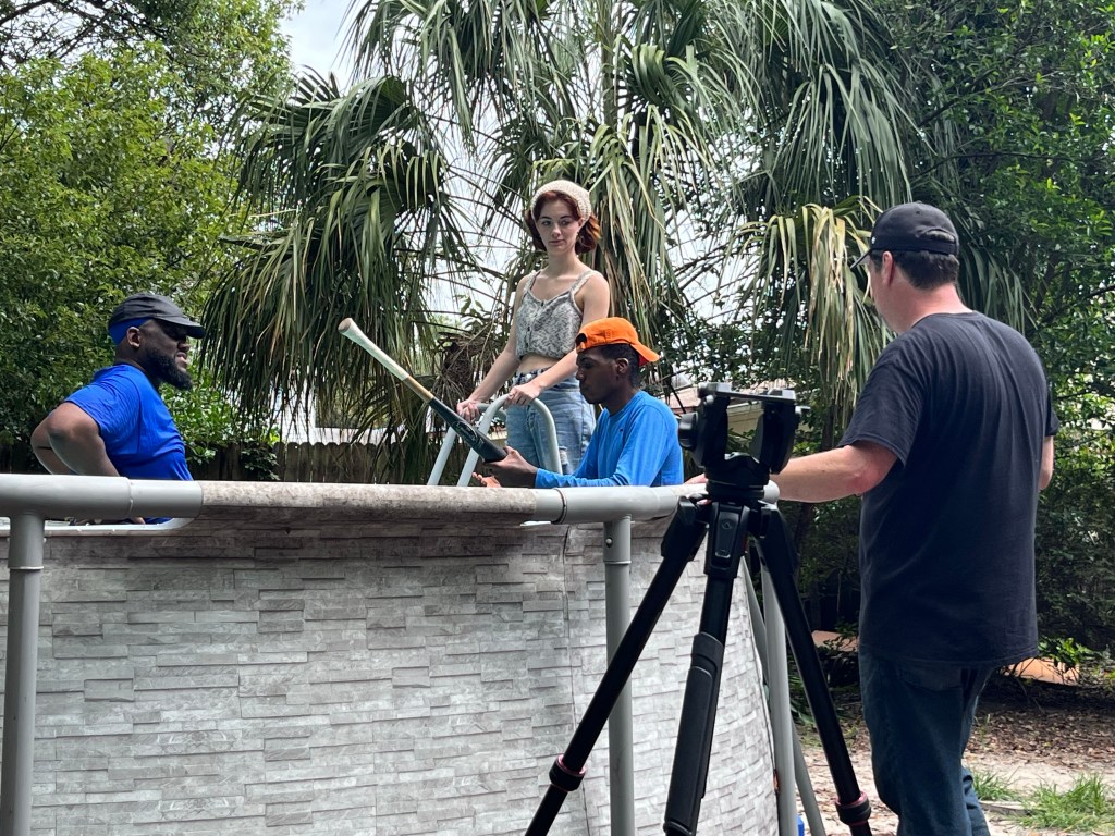 Group filming a pool scene.