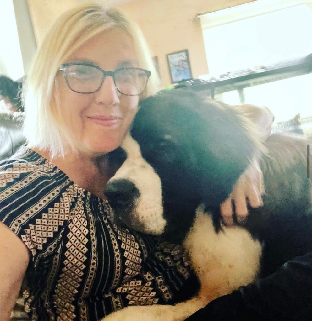 Woman cuddles her Saint Bernard