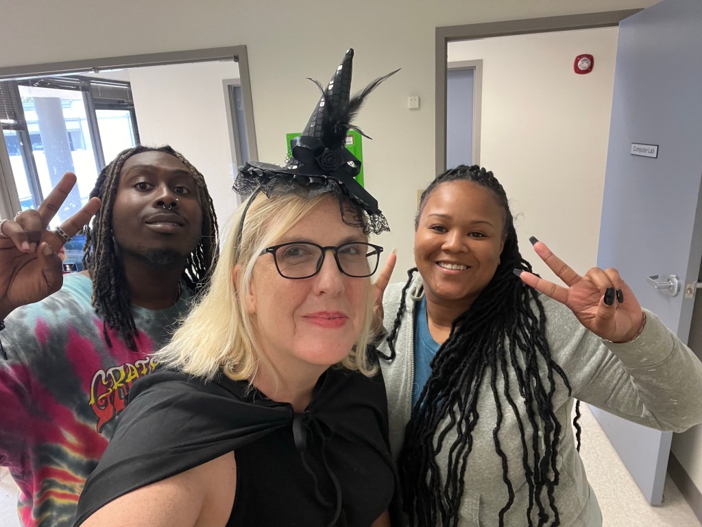 White woman and two black coworkers pose for a picture.
