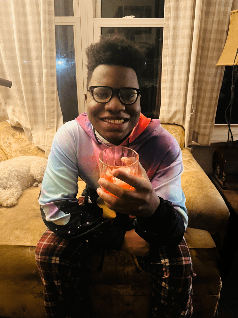 boy holding glass, wearing glasses