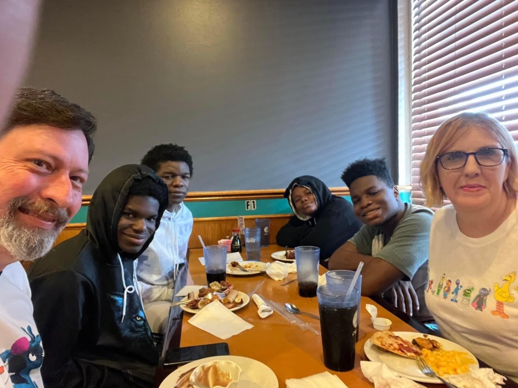 Transracial adoptive family smile for a picture at Chinese restaurant